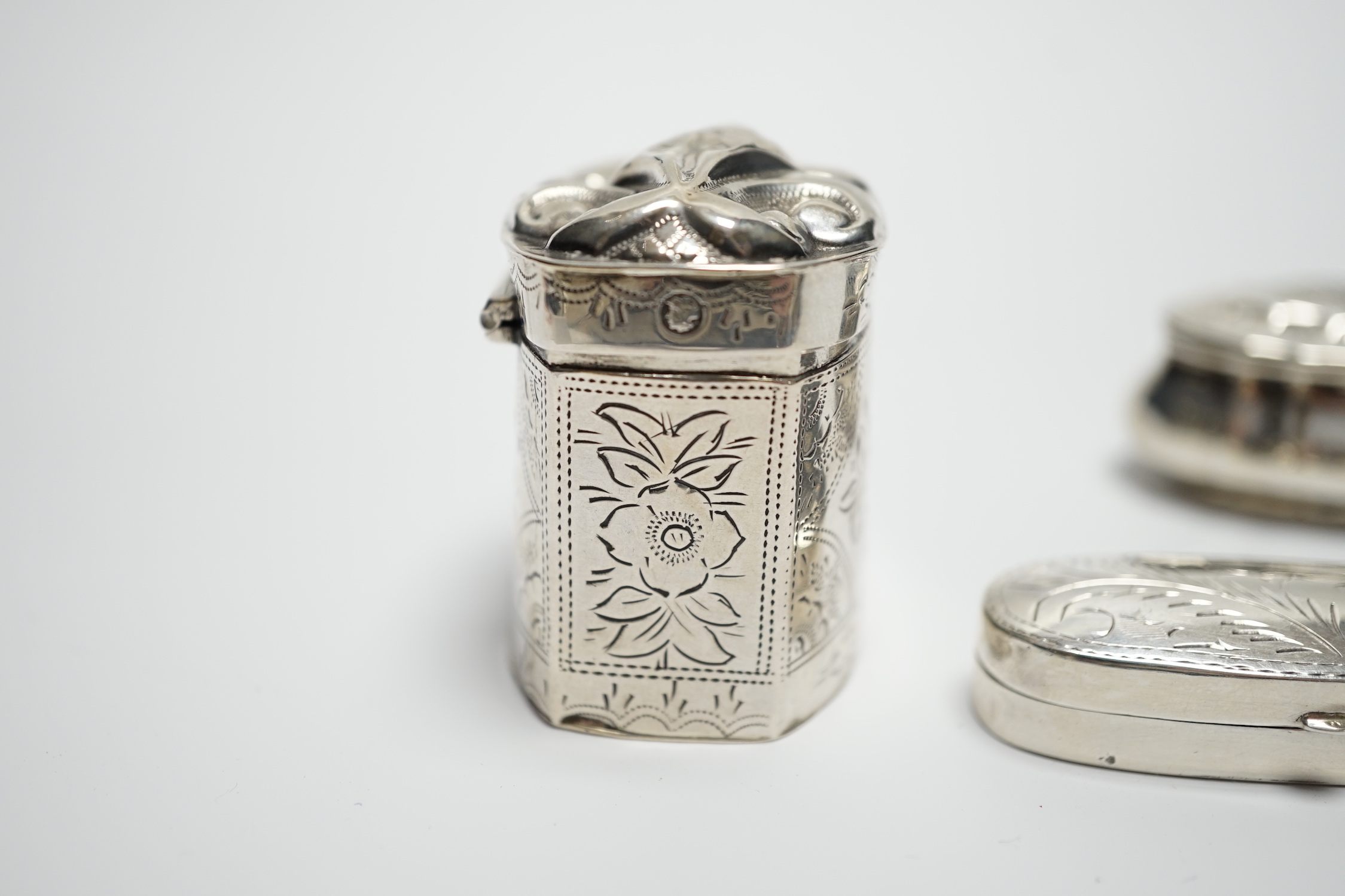 A late Victorian silver pill box with Reynold's Angel decorated cover, 47mm, a modern silver pill box and a Dutch white metal box.